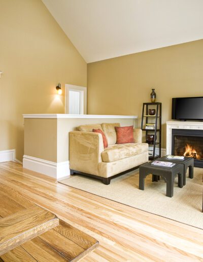 Cozy living room with a fireplace, hardwood floors, and comfortable seating.