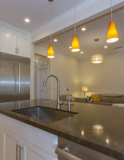 Modern kitchen with stainless steel appliances, white cabinetry, and pendant lighting over an island countertop.