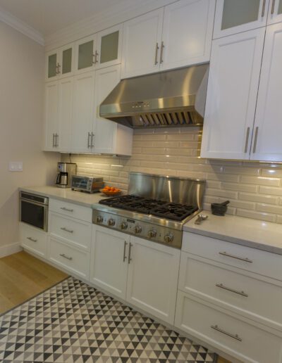 Modern kitchen interior with stainless steel appliances and white cabinetry.