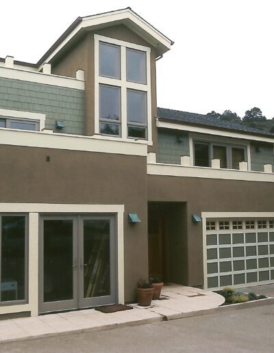 Modern two-story house with large windows and an attached garage.